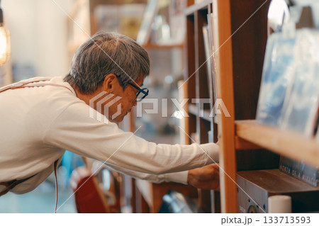 お店の棚からお気に入りを探す60代女性のシーン 133713593