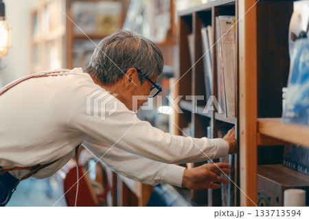 お店の棚からお気に入りを探す60代女性のシーン 133713594