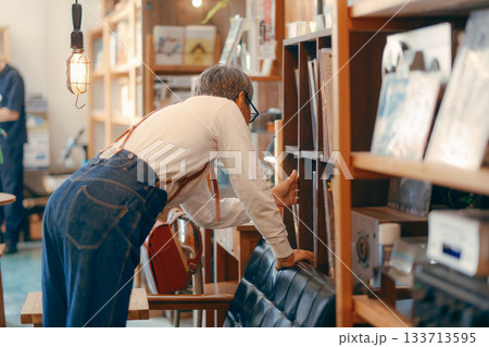 お店の棚からお気に入りを探す60代女性のシーン 133713595