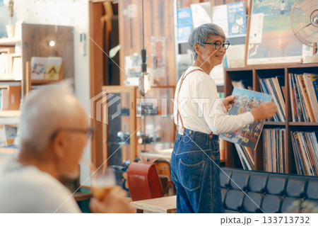 レコードを選ぶ60代夫婦のリラックスした店内シーン レコードを選ぶ60代夫婦のリラックスした店内シーン 133713732
