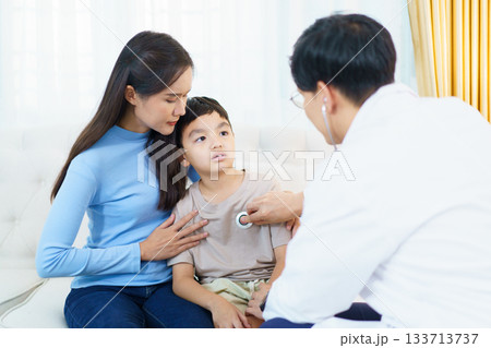 A doctor is performing a health check-up on a young boy, using a stethoscope to listen to his breathing and heartbeat. 133713737