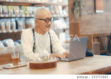 カフェでパソコン作業をする60代男性のリラックスシーン カフェでパソコン作業をする60代男性のリラックスシーン 133713881