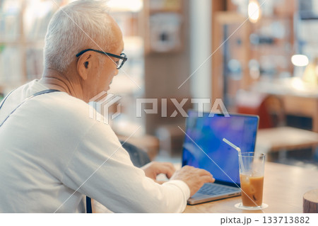 カフェでパソコン作業をする60代男性のリラックスシーン カフェでパソコン作業をする60代男性のリラックスシーン 133713882