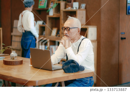 カフェでパソコン作業をする60代男性のリラックスシーン カフェでパソコン作業をする60代男性のリラックスシーン 133713887