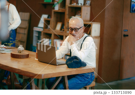 カフェでパソコン作業をする60代男性のリラックスシーン 133713890