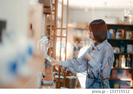 カフェ雑貨を手に取る20代女性のローカル散策シーン カフェ雑貨を手に取る20代女性のローカル散策シーン 133715512