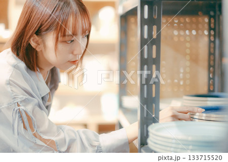 カフェ雑貨を手に取る20代女性のローカル散策シーン カフェ雑貨を手に取る20代女性のローカル散策シーン 133715520