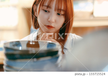 カフェ雑貨を手に取る20代女性のローカル散策シーン カフェ雑貨を手に取る20代女性のローカル散策シーン 133715524