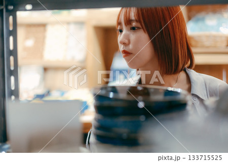 カフェ雑貨を手に取る20代女性のローカル散策シーン カフェ雑貨を手に取る20代女性のローカル散策シーン 133715525