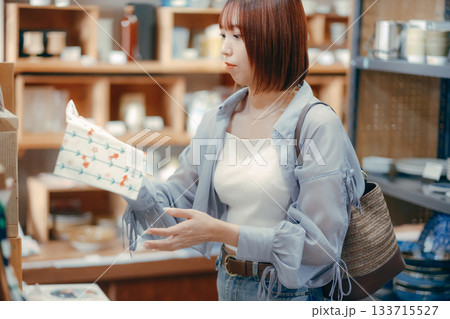 カフェ雑貨を手に取る20代女性のローカル散策シーン カフェ雑貨を手に取る20代女性のローカル散策シーン 133715527