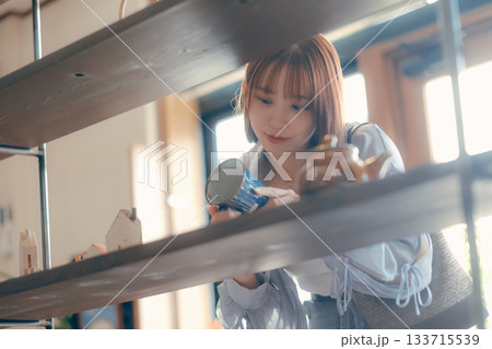 カフェ雑貨を手に取る20代女性のローカル散策シーン カフェ雑貨を手に取る20代女性のローカル散策シーン 133715539