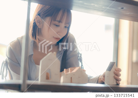カフェ雑貨を手に取る20代女性のローカル散策シーン 133715541