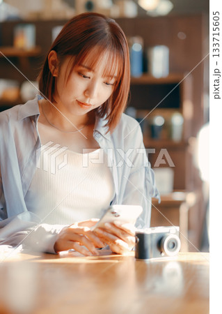カフェでまったり過ごす20代女性とカメラのある時間 カフェでまったり過ごす20代女性とカメラのある時間 133715605