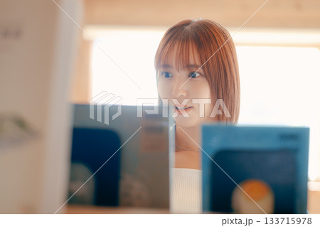 コワーキングスペースで読書をする20代女性のシーン 133715978