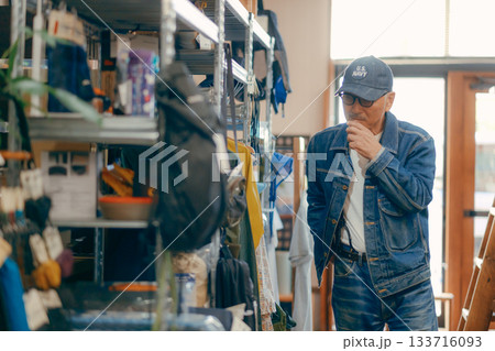 店内で雑誌を手に取る60代男性の日常シーン 133716093