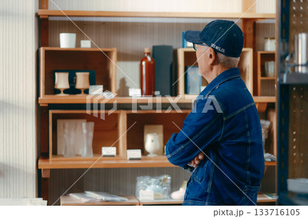 店内で雑誌を手に取る60代男性の日常シーン 133716105