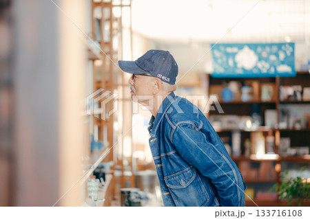 店内で雑誌を手に取る60代男性の日常シーン 店内で雑誌を手に取る60代男性の日常シーン 133716108