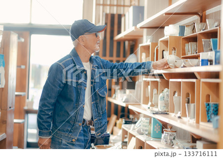 店内で雑誌を手に取る60代男性の日常シーン 133716111