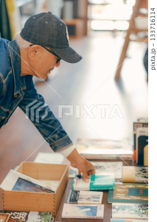 店内で雑誌を手に取る60代男性の日常シーン 133716114