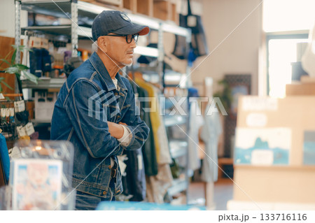 店内で雑誌を手に取る60代男性の日常シーン 133716116