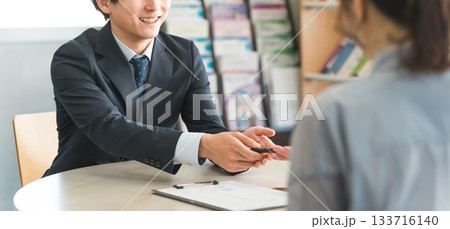 女性客と商談する若いアジア人ビジネスマン（自動車・保険） 133716140