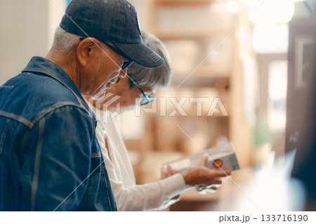 店内で商品を選ぶシニア夫婦の日常シーン 店内で商品を選ぶシニア夫婦の日常シーン 133716190