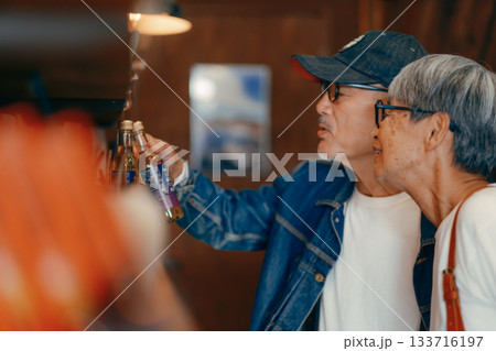 店内で商品を選ぶシニア夫婦の日常シーン 133716197