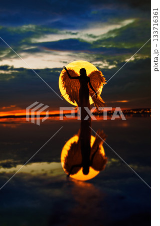Young lady with wings in fight circle, night photography, dramatic sky, water reflection Young lady with wings in fight circle, night photography, dramatic sky, water reflection 133716361
