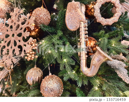 Christmas ornaments on the Christmas tree. Toys and gold stars. 133716459