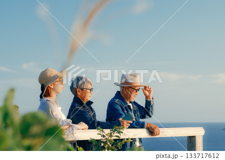 夕暮れの海を眺める親子の黄昏シーン 夕暮れの海を眺める親子の黄昏シーン 133717612