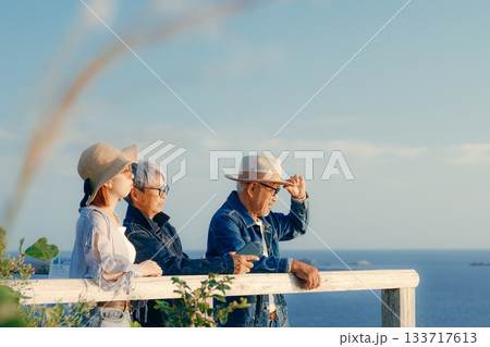 夕暮れの海を眺める親子の黄昏シーン 夕暮れの海を眺める親子の黄昏シーン 133717613