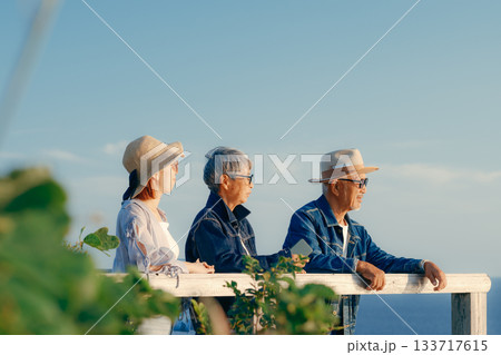 夕暮れの海を眺める親子の黄昏シーン 夕暮れの海を眺める親子の黄昏シーン 133717615