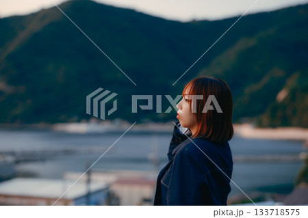 夕景を見つめる女性の黄昏ポートレート 133718575