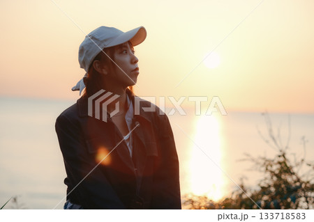 夕景を見つめる女性の黄昏ポートレート 133718583