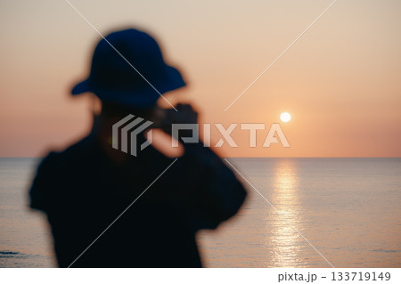 夕日を眺めるシニア女性のシルエット 133719149