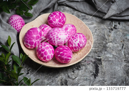 Lace pattern painted pink Easter eggs on a plate top view 133719777