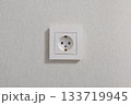 One white outlets are on a white wall. 133719945