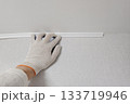 A person is wearing gloves glues a polypropylene corner 133719946