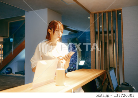 スマホでチェックインする20代女性 133720303