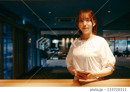 スマホでチェックインする20代女性 133720311