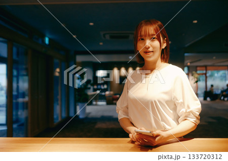 スマホでチェックインする20代女性 スマホでチェックインする20代女性 133720312