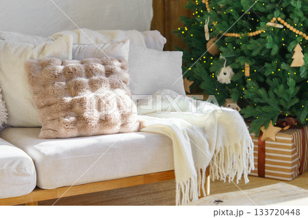 Cozy living room with decorated Christmas tree, warm sofa textiles and wrapped gifts for holidays Cozy living room with decorated Christmas tree, warm sofa textiles and wrapped gifts for holidays 133720448
