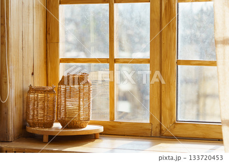 Cozy autumn scene with two wicker lanterns on wooden windowsill and blurred yellow forest background Cozy autumn scene with two wicker lanterns on wooden windowsill and blurred yellow forest background 133720453