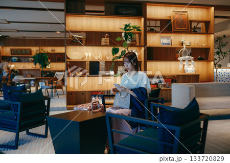 ホテルロビーでパソコン作業をする20代女性 133720829