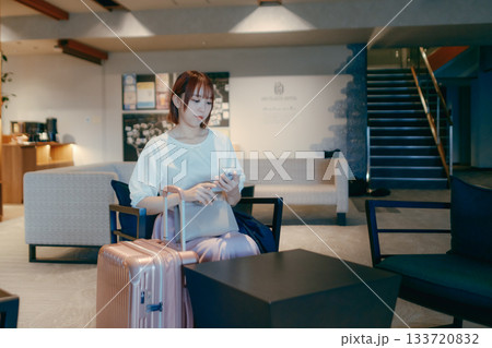 ホテルロビーでパソコン作業をする20代女性 133720832