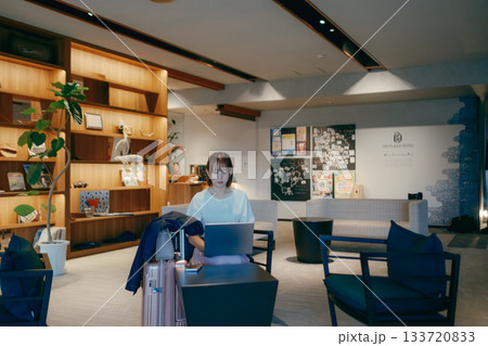 ホテルロビーでパソコン作業をする20代女性 133720833