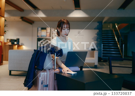 ホテルロビーでパソコン作業をする20代女性 133720837
