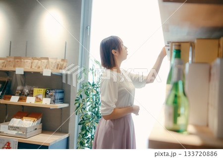 ホテルのお土産コーナーで地酒を選ぶ20代女性OL 133720886