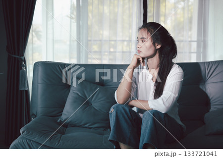 Sorrowful woman sat alone, overwhelmed by emotion, her sad and unhappy expression revealing deep despair, stress and distress left feeling depressed. sorrowful sad, despair alone, depressed stress 133721041