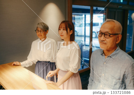 親子三人がホテルでチェックインするシーン 133721086